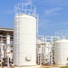 white liquid storage tanks outside industrial facility